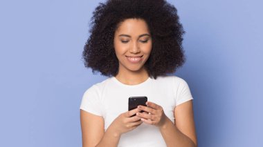 Gülümseyen Afrikalı Amerikalı kız modern cep telefonu mesajları kullanıyor.