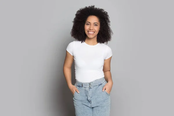 Smiling biracial millennial girl posing on grey background — Stock Photo, Image