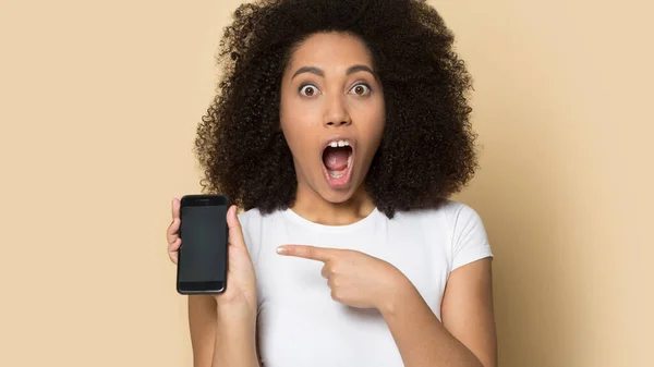 Shocked biracial milenial chica punto en oferta en el teléfono inteligente — Foto de Stock