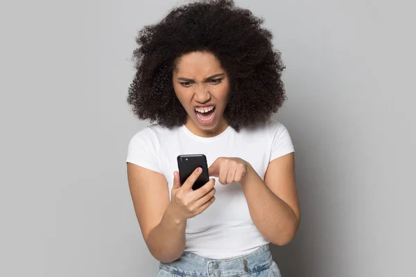 Boos biracial meisje krijgen nerveus met mobiele telefoon problemen — Stockfoto