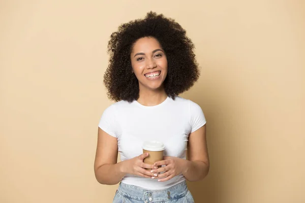 Улыбающаяся африканская американская девушка тысячелетия наслаждается кофе на вынос — стоковое фото