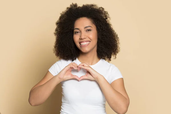 Sonriente biracial chica mira a la cámara hacer el gesto del corazón — Foto de Stock