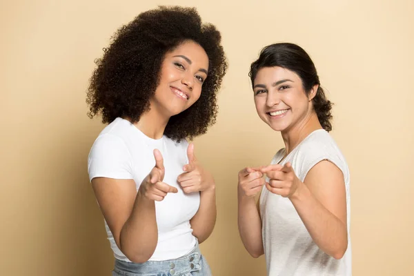Leende multietnisk flicka peka på klient poserar i studio — Stockfoto