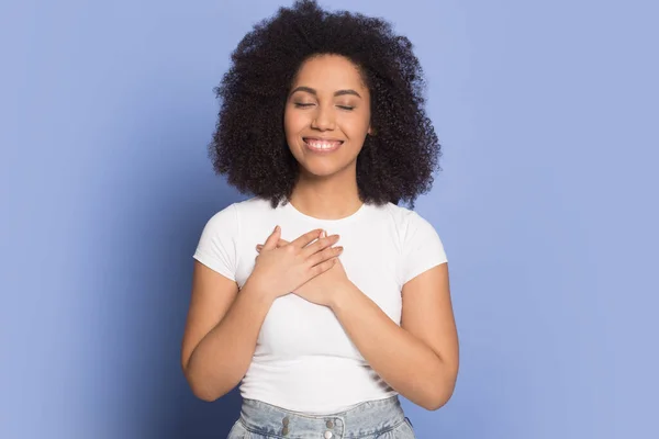 Grateful happy biracial girl hold hands at chest — Stock Photo, Image