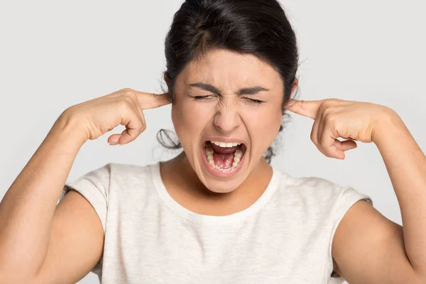 Mad menina étnica gritar incomodado por som perturbador — Fotografia de Stock