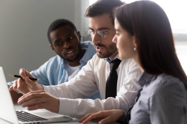 Kendine güvenen takım liderini dinleyen konsantre karışık ırk çalışanları..