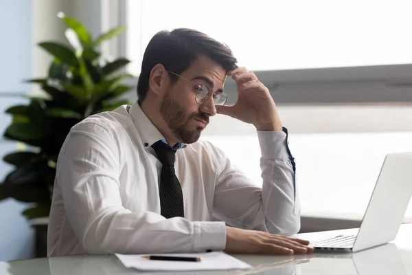 Gerente pensativo mirando la pantalla de la computadora, haciendo difícil la decisión . — Foto de Stock