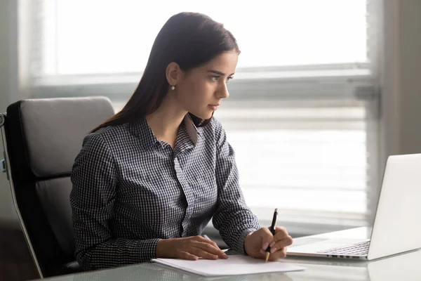 Gericht jonge zelfverzekerde zakenvrouw werken met papieren documenten. — Stockfoto