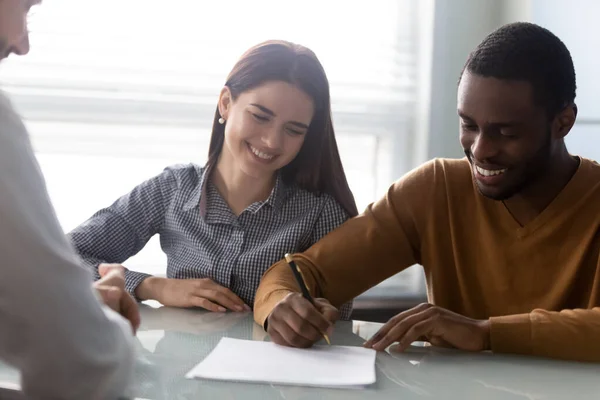 Giovane donna sorridente guardando il marito firmare un contratto . — Foto Stock