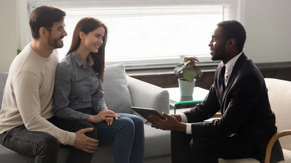 Sonriente joven familia pareja reunión agente de bienes raíces en casa . — Foto de Stock