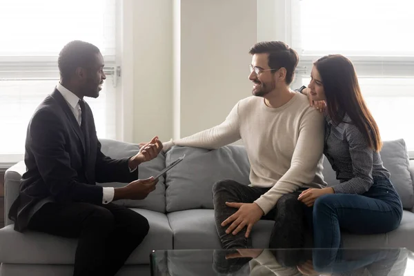 Happy young family couple listening to financial expert offer.