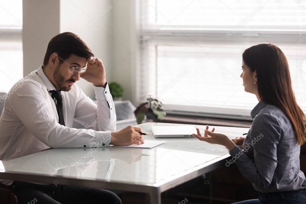 Confused male hr manager listening to female job applicant.