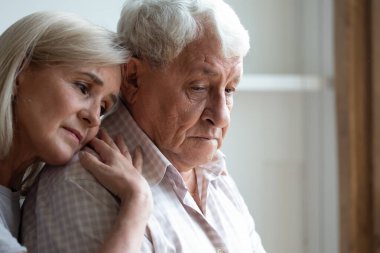 Orta yaşlı kızı, yaşlı babasına sarılıp acısını paylaşıyor.