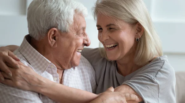 Close-up gezichten bejaarde vrouw en senior man omarmen binnen — Stockfoto