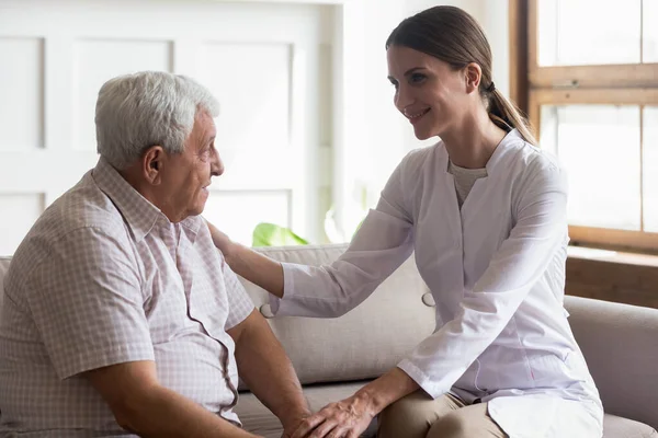 Alter Mann Patient und sorgfältige Krankenschwester oder Pfleger Kommunikation in Innenräumen — Stockfoto