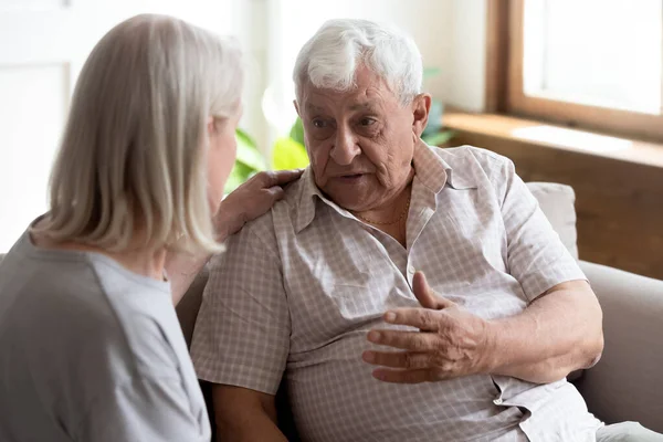 Enfermera geriátrica escucha a anciano mostrando cuidado y apoyo —  Fotos de Stock