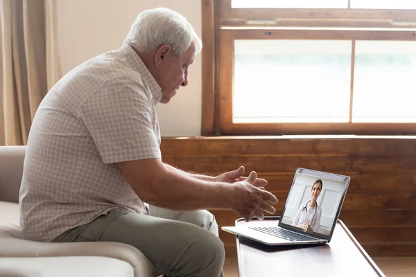 Uomo anziano fare videochiamata lontano comunicare con il medico online — Foto Stock