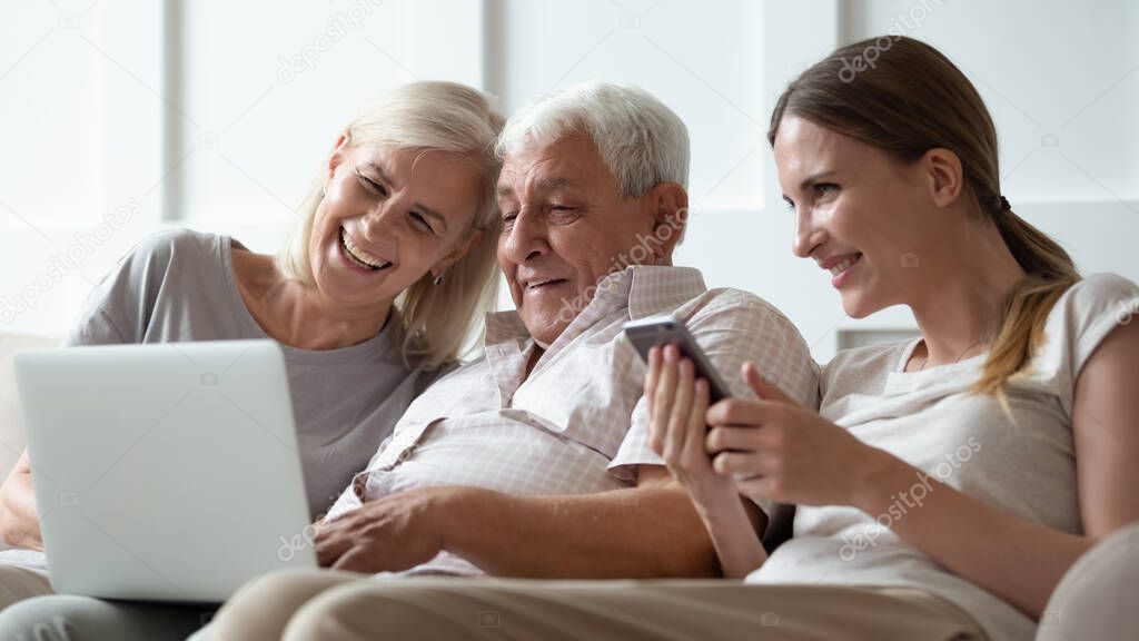 Three generations family with modern gadgets at home