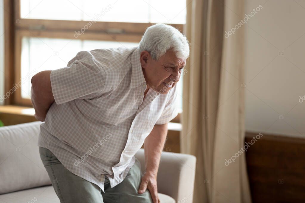 Senior man got up from couch felt low back pain
