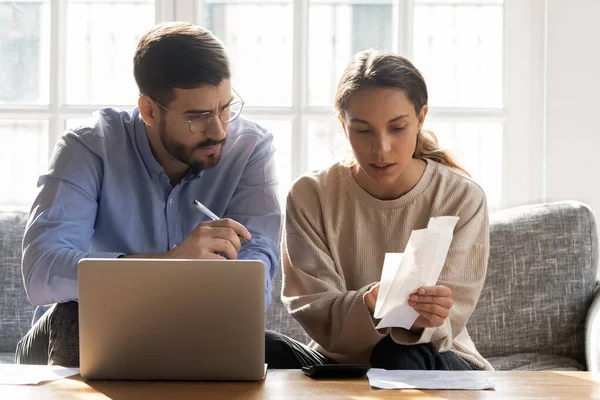 Serious couple calculating expenses, bills together, using laptop — Stock Photo, Image