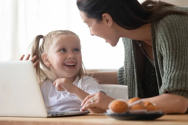 Mãe feliz e filha pequena se divertindo com laptop — Fotografia de Stock