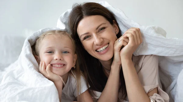 Голова портрет счастливая мать и маленькая дочь в постели — стоковое фото