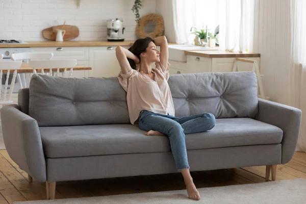 Calm serene young woman relaxing on couch at home — Stock Photo, Image