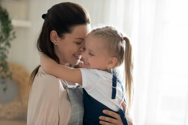 Küçük kızını kucaklayan mutlu anne, şefkatli anın tadını çıkarıyor. — Stok fotoğraf