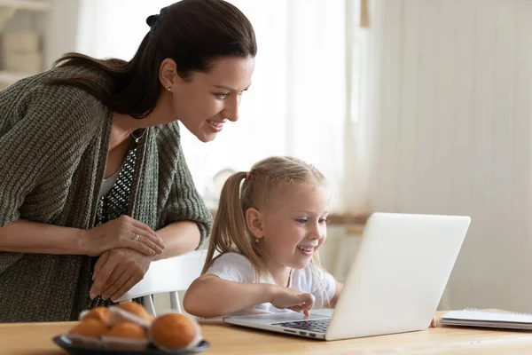 Sorrindo mãe e filha usando laptop, olhando para a tela — Fotografia de Stock