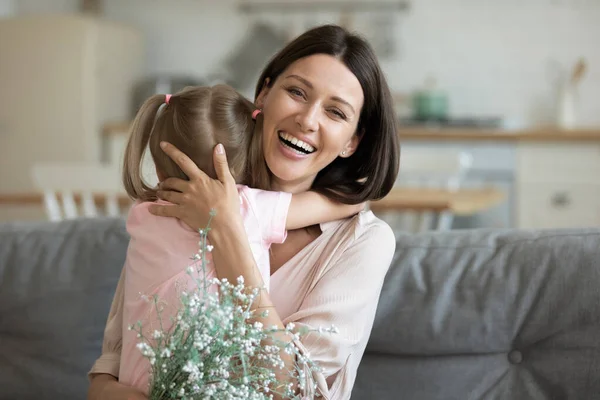 Testa ritratto madre abbracciando figlioletta, ringraziando per i fiori — Foto Stock