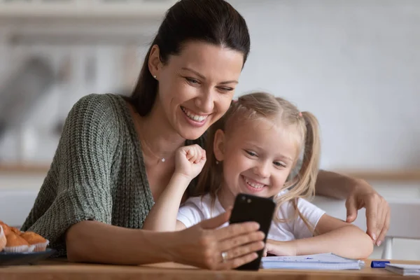 Усміхнена мати і маленька дочка приймають селфі по телефону — стокове фото