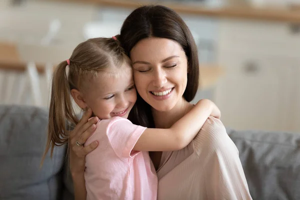 Glücklich liebende Mutter umarmt kleine Tochter, genießt freie Zeit zusammen — Stockfoto