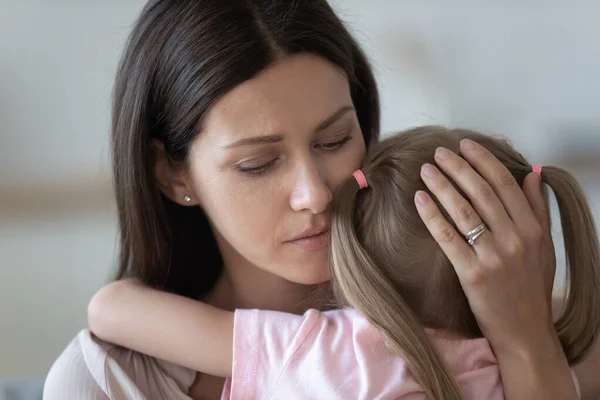 Verontwaardigde liefdevolle moeder omarmen, troostende kleine dochter close up — Stockfoto