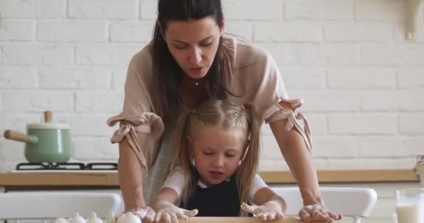 Felice mamma insegnamento carino bambino figlia rotolamento pasta in cucina — Video Stock