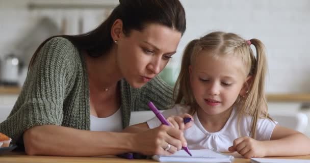 Feliz mamá enseñando dibujo de niña con fieltro pluma juntos — Vídeo de stock