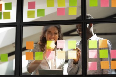 Çeşitli iş arkadaşları yeni düşünceler yazıyor yapışkan notlar üzerine yeni fikirler.