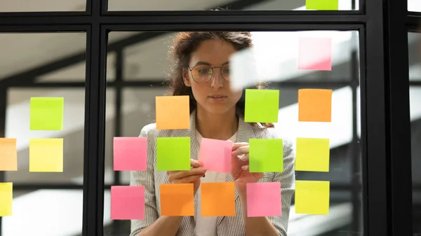Donna d'affari che crea un elenco di cose da fare utilizzando note adesive multicolori — Foto Stock