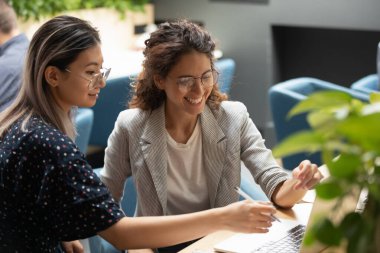 İş yerinde birlikte çalışan bilgisayar kullanan kadın meslektaşlar