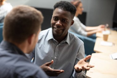 Afrikalı bir ofis çalışanı beyaz meslektaşıyla düşünce ve becerilerini paylaşıyor