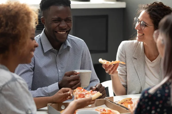 Team van multiraciale collega 's eten pizza genieten lunchpauze — Stockfoto