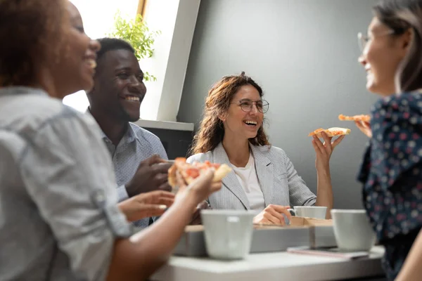 Miembros de la compañía multirracial almorzando comiendo pizza durante el descanso — Foto de Stock