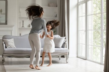 Neşeli genç anne tatlı kızıyla birlikte atlıyor..