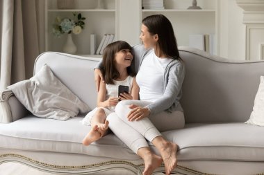 Neşeli küçük kız ve mutlu anne birlikte eğleniyor..