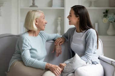 Büyümüş çekici kızıyla iletişim kuran mutlu yaşlı kadın..