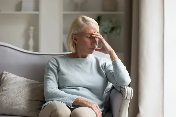 Exhausted mature lady suffering from head ache at home. — Stock Photo, Image