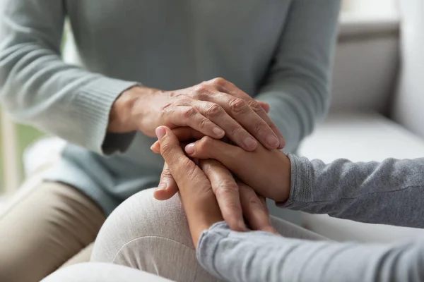 Cerca de la joven y la mujer de mediana edad que conecta las manos . — Foto de Stock