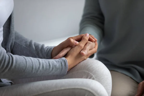 Cuidado de la mujer joven cogida de la mano de la madre mayor . — Foto de Stock