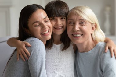 Mutlu sevimli küçük kız gülümseyen anne ve olgun büyükanne.