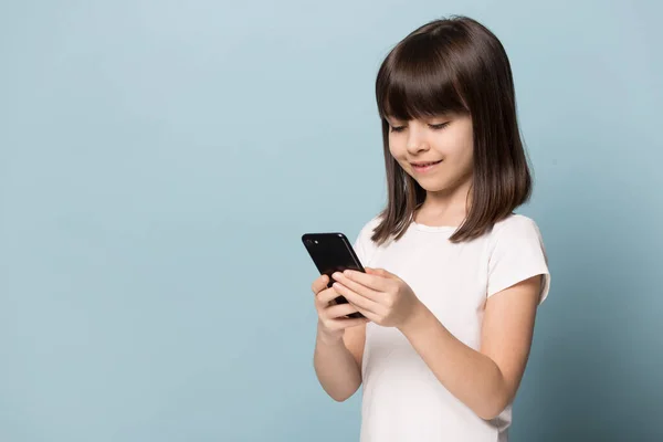 Klein meisje met behulp van moderne smartphone kijken cartoons — Stockfoto