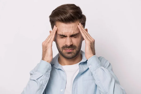 Unwohlsein kaukasischer Mann massiert Schläfen mit starken Kopfschmerzen — Stockfoto
